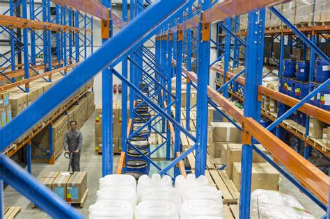 Warehouseman In Storehouse Working With Pallet Jack Stock Photo