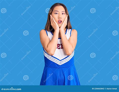 Young Beautiful Chinese Girl Wearing Cheerleader Uniform Afraid And