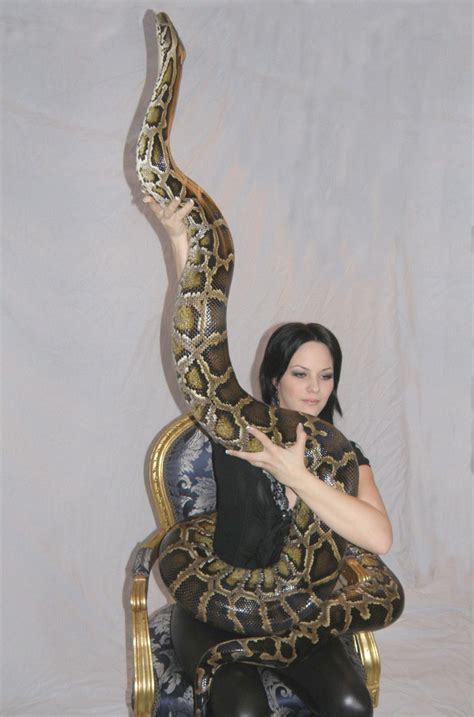 A Woman Sitting In A Chair With A Large Snake On It S Arm