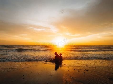 Silhouette of Children Sitting by the Beach during Golden Sunset Stock ...