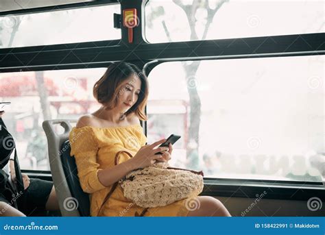 Young Beautiful Asian Woman Browsing And Typing Messages In A Public