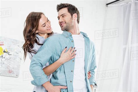 Woman Hugging Handsome Man From Behind At Home Stock Photo Dissolve