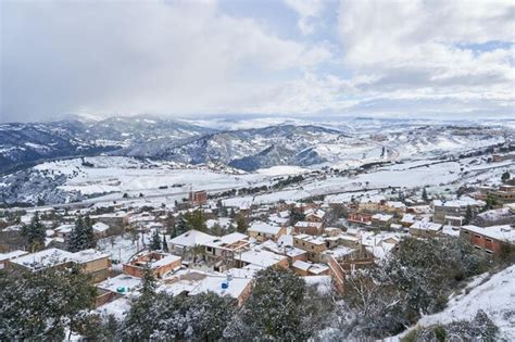 Un Paisaje Nevado Con Un Pueblo En Primer Plano Y Nieve En El Suelo