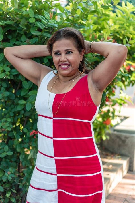 Hispanic Woman In Dress Cell Phone In Hand Looking At Camera Stock