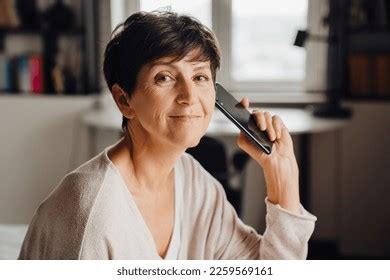 Smiling Shorthaired Mature Woman Talking On Stock Photo 2259569161