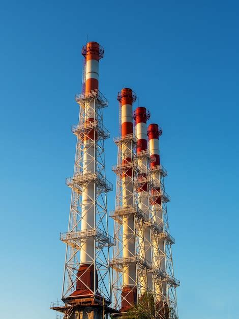 Premium Photo Four Industrial Chimneys Against A Blue Sky