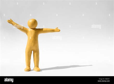 Human Figure With Arms Wide Open Made Of Yellow Plasticine On White