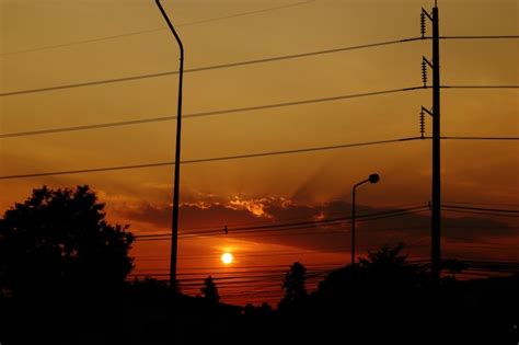 Premium Photo | Orange sunset behind dark silhouette of town.