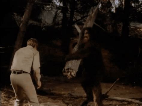 an old photo of two men playing baseball in the woods, one holding a bat