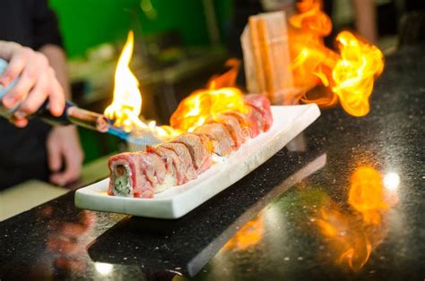 Man`s Hand Holding Torch Burner Chef Prepares Sushi Stock Image