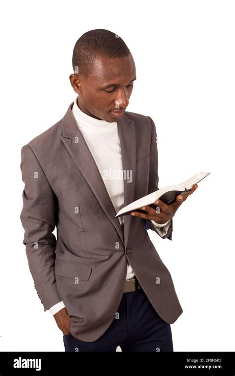 Portrait Of Young Pastor Standing And Reading A Bible In His Hand Stock