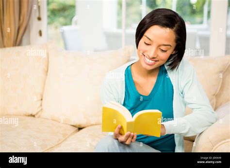 Smiling Brunette Reading Book On The Sofa Stock Photo Alamy
