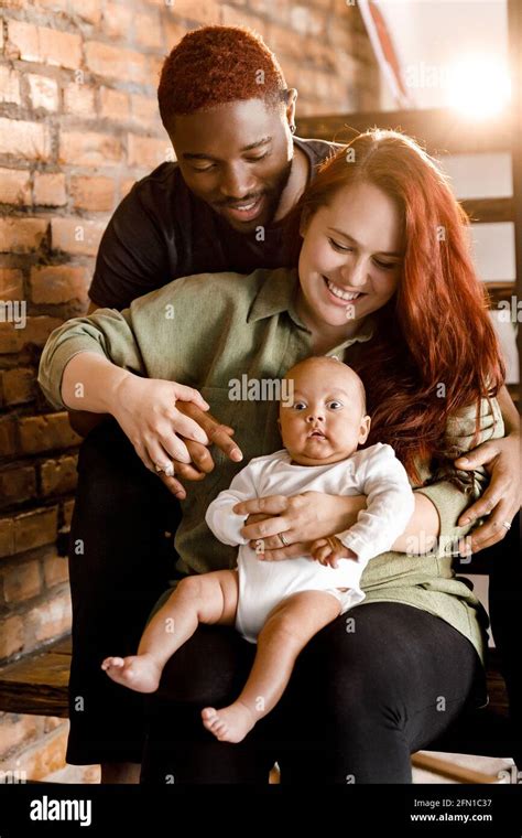 Portrait of mixed race smiling family sit on the stairs. Beautiful ...