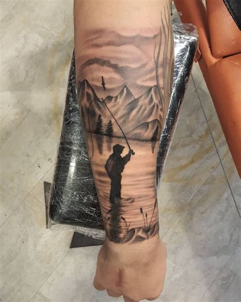 A Person With A Fishing Tattoo On Their Arm Holding A Pole In Front Of