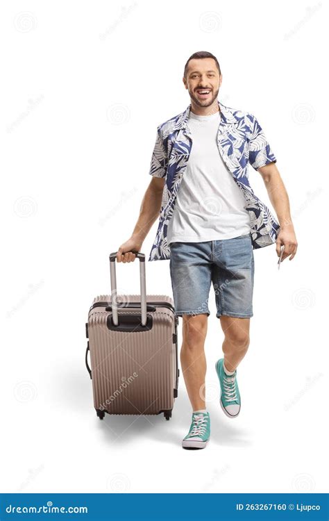 Full Length Portrait Of A Smiling Man Walking And Pulling A Suitcase