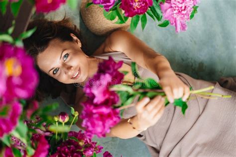 Attractive Brunette Nude Breast Woman With A Bouquet Of Peonies On The