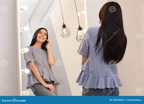 Young Attractive Woman Looking At Herself In Mirror At Home Stock Image