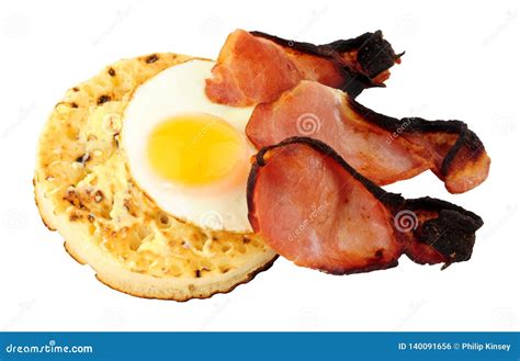 Fried Egg And Bacon Rashers On A Large English Crumpet Stock Photo