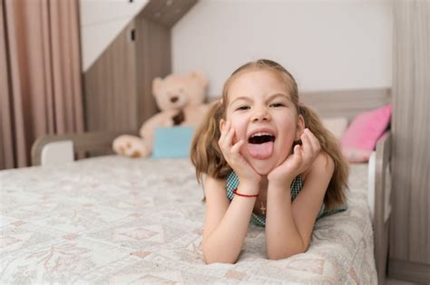 Jolie Fille Fait Des Grimaces Sur Le Lit Photo Gratuite