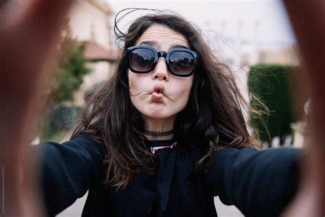 Grimacing Woman Taking Selfie By Stocksy Contributor Guille Faingold