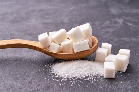 White Sugar Cubes In Wooden Spoon On Black Table Stock Photo Image Of