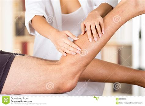 Female Physio Therapist Hands Working On Male Patients Lower Leg And