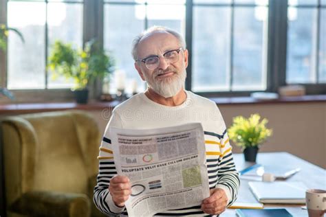 Grey Haired Bearded Man In Eyewear Smiling Nicely While Reading A