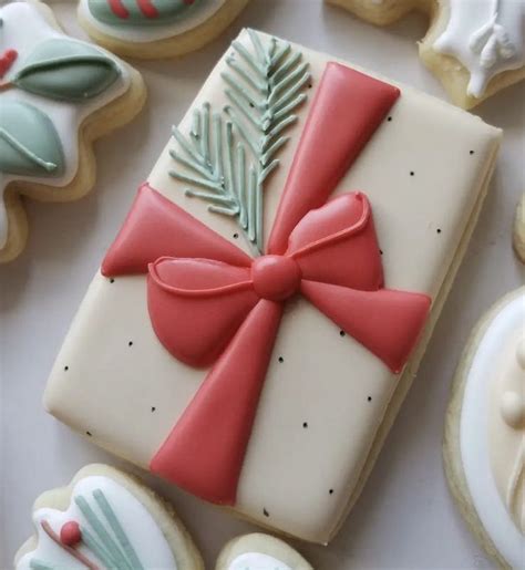 Decorated Christmas Cookies With Red Ribbon And Bow On White Tablecloth