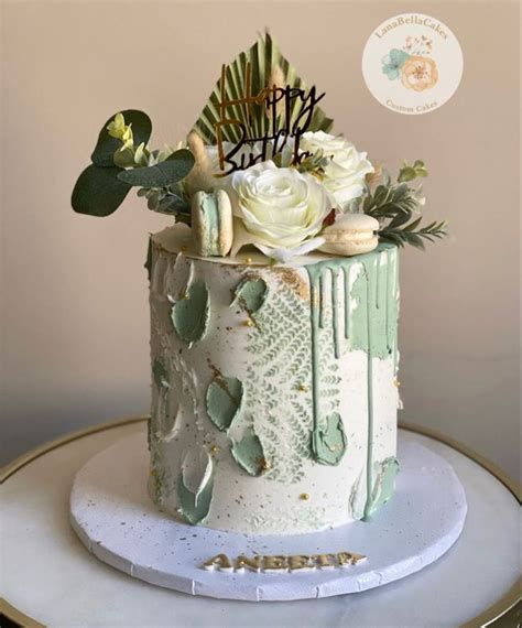 A White And Green Cake With Flowers On Top