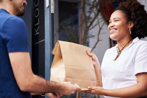 Delivery Man Package And A Woman At Door With A Smile And Paper Bag