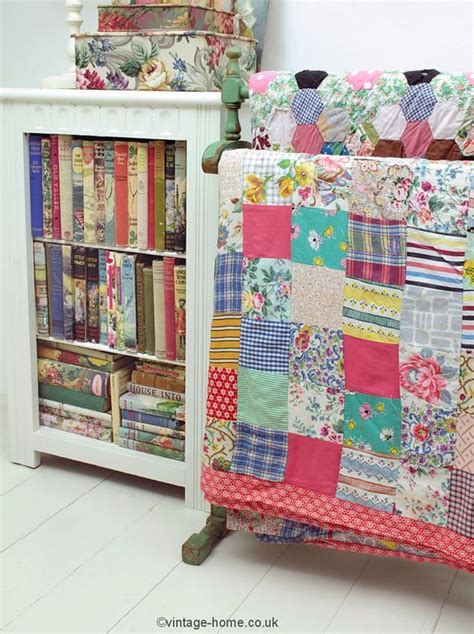 A Collection Of Vintage Books And Old Patchwork Quilts Displayed On The