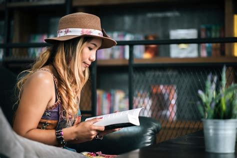 Premium Photo Woman Reading Book While Sitting In Library