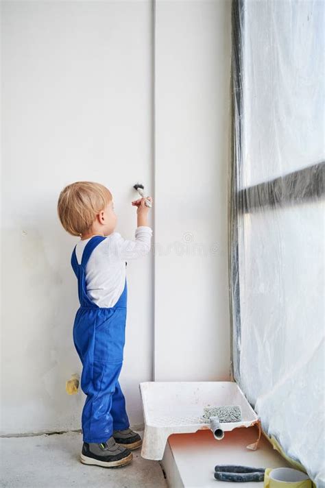 Child Painting Wall With Paint Brush In Apartment Under Renovation