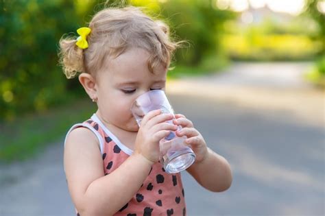 El Ni O Bebe Agua De Un Vaso Enfoque Selectivo Foto Premium