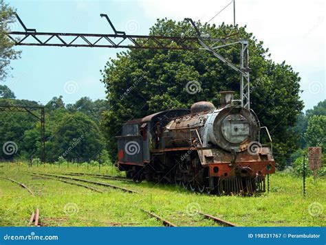 View Of An Old Rusted Steam Locomotive At An Abandoned Station Stock