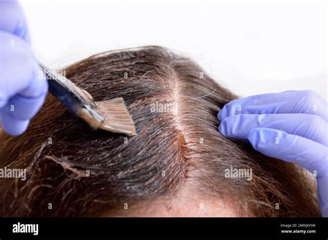 Close Up A Brunette Woman Dying Her Hair With White Background Stock