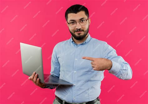 Free Photo Young Bearded Man In Glasses And Blue Shirt Holding Laptop