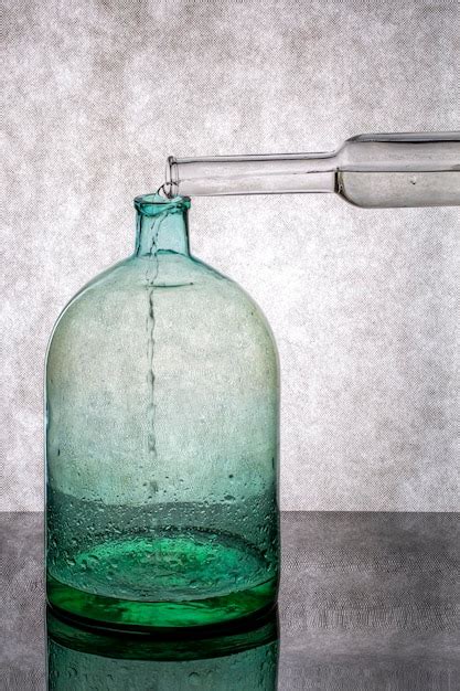 Premium Photo Pouring Water From A Bottle Into A Glass Jar