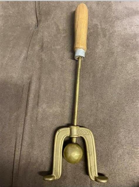 Metal Rod With Ball And U Shaped Thing On The End Has A Wooden Handle