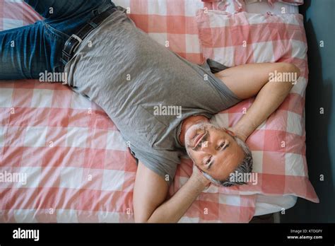 Relaxed Mature Man Lying On Bed Stock Photo Alamy
