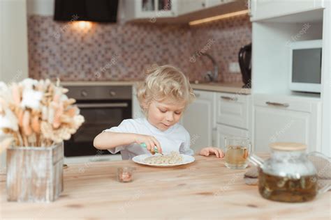 Niño En La Cocina En La Mesa Comiendo Arroz Vista Frontal Foto Premium