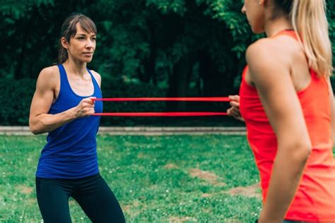 Premium Photo Female Athletes Exercising With Resistance Bands At Park