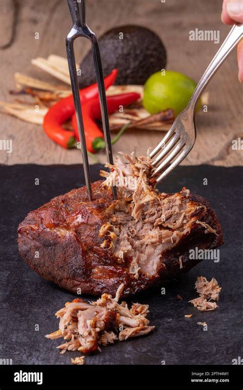 pulling pulled pork on slate Stock Photo - Alamy