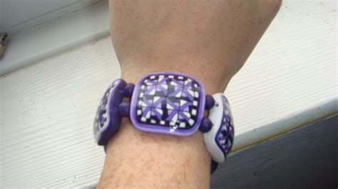 A Purple And White Watch On Someone S Wrist