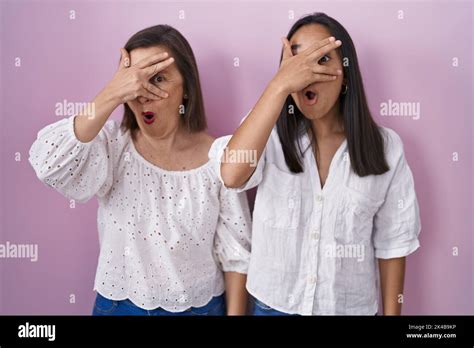 Hispanic Mother And Daughter Together Peeking In Shock Covering Face