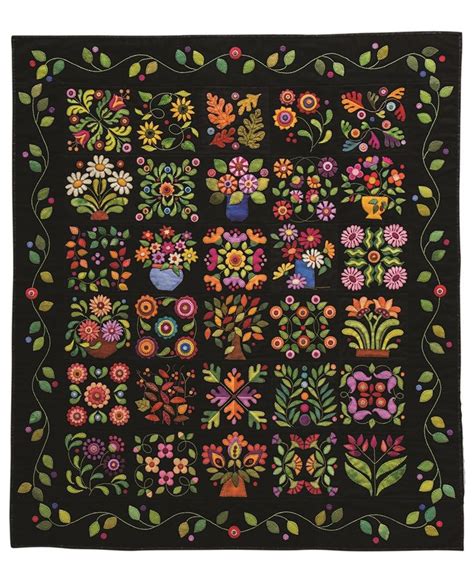 A Black Quilt With Colorful Flowers And Vases On The Front Surrounded