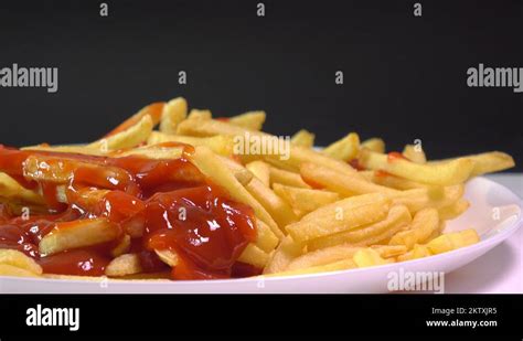 Female And Male Hands Picking French Fries And Dipping Them In Tomato