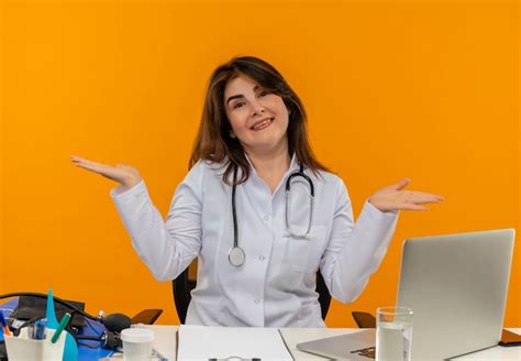 Sonriente doctora de mediana edad vistiendo bata médica con