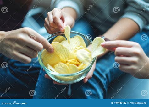 Friends Sharing And Eating Potato Chips At Home Party Stock Photo