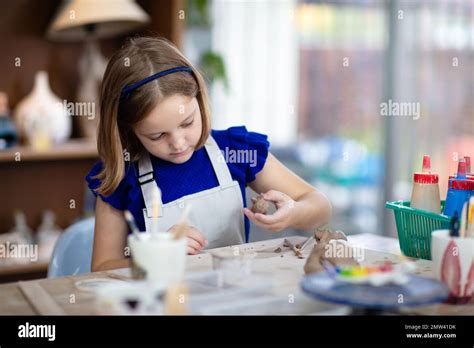 Niño trabajando en rueda de alfarería Los niños de la clase de artes y